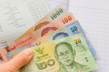 Thai banknotes on book bank and account book background