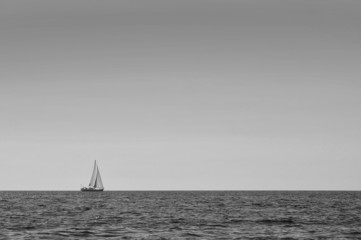 Sailboat alone at open sea black and white