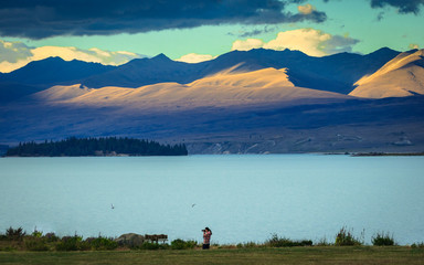 Woman taking photo at lake, New zealand