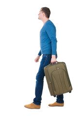 back view of walking  man in pullover with suitcase.