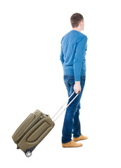 Back view of man with  green suitcase looking up.