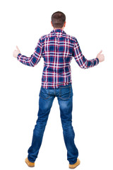 Back view of  man in checkered shirt shows thumbs up.