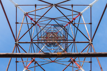 High-voltage tower against blue sky background.