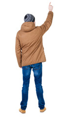 Naklejka premium Back view of pointing young men in parka.