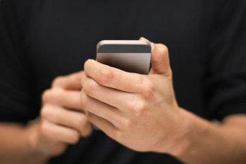 Closeup of male hands using a smartphone