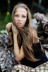 Naklejka premium The resting young girl in the woods. Long hair dispelled by wind