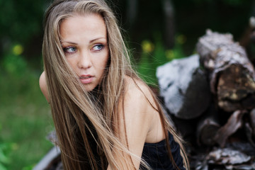 Naklejka premium The resting young girl in the woods. Long hair dispelled by wind