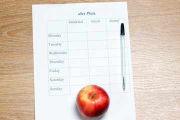 diet Plan. diet plan, pencil and apple lying on a wooden surface