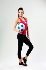 woman with soccer ball on gray background