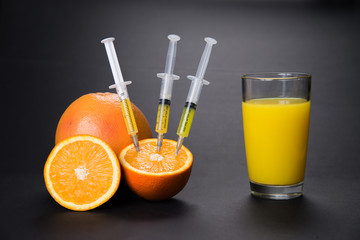 Orange with vitamins in the syringe