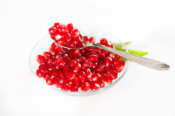 Ripe pomegranate seeds on a glass plate.