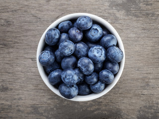 fresh blueberries in white bowl on wood table