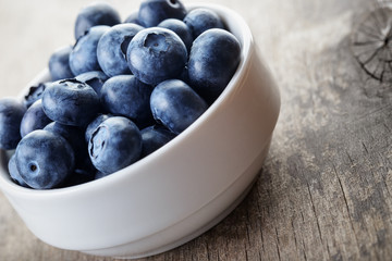 fresh blueberries in white bowl on wood table