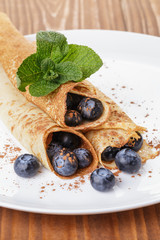 homemade blinis or crepes with blueberries and jam