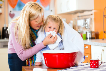 Mutter pflegt krankes Kind mit Dampfbad 