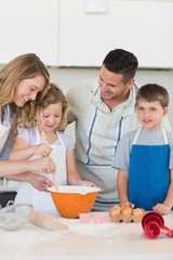 Parents assisting children in baking cookies