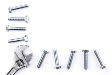 Screws and spanner on white background