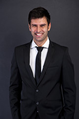 businessman standing on dark background with big smile