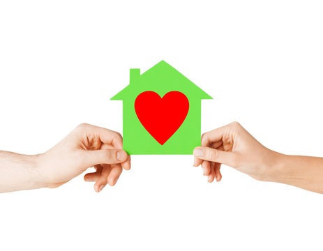 couple hands holding green paper house