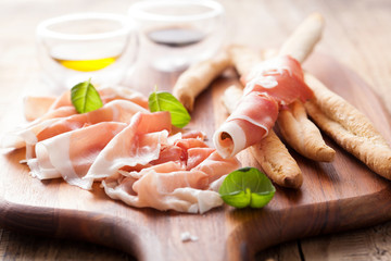 italian prosciutto ham grissini bread sticks olive oil
