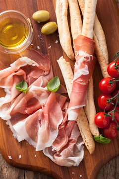 italian prosciutto ham grissini bread sticks tomato olive oil