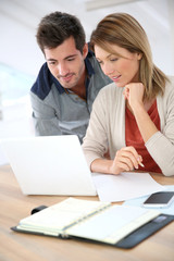 Couple at home checking accounts on internet