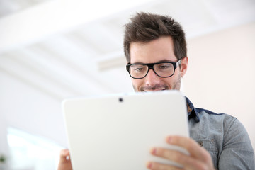 Man with eyeglasses websurfing with touchpad