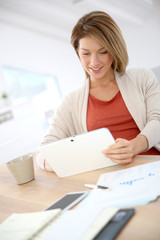 Woman working from home on digital tablet