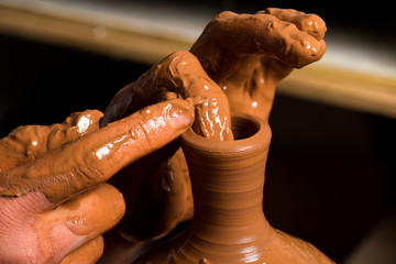hands of a potter, creating an earthen jar