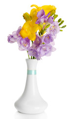 Beautiful bouquet of freesias in vase, isolated on white
