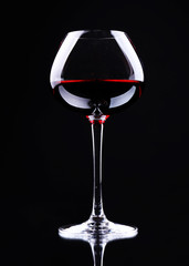 Wineglass with red wine, isolated on black