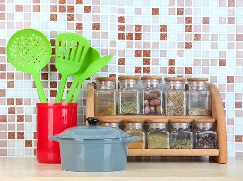 Set of spices, tableware and kitchen utensils in kitchen