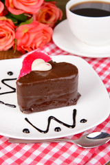 Sweet cake with chocolate on plate on table close-up