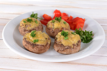 Stuffed mushrooms on plate on table on light background