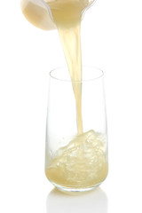 Juice pouring into glass isolated on white