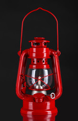 Red kerosene lamp on black background