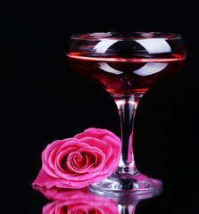 Composition with pink sparkle wine in glass and  rose isolated