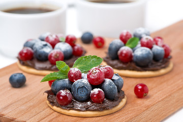 cake with chocolate cream and berries on a wooden board