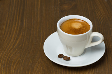 cup of coffee with foam on a wooden table