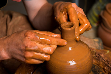 hands of a potter, creating an earthen jar