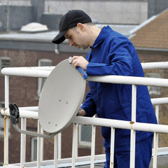 Techniker montiert Satelliten-Schüssel