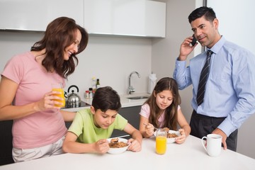 Kids with parents having breakfast in kitchen