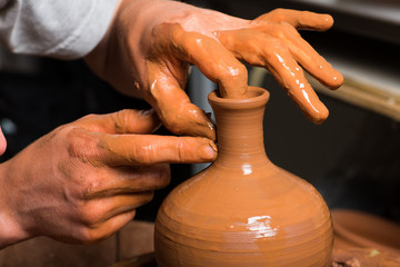hands of a potter, creating an earthen jar