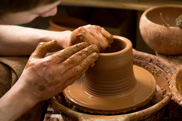 hands of a potter, creating an earthen jar