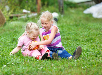 Naklejka na ściany i meble two girls playing on the green grass