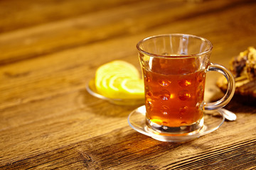 Glass of hot tea on rustic wooden table.