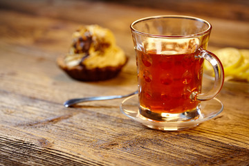 Glass of hot tea on rustic wooden table.