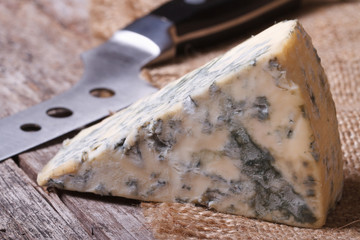 Blue cheese on sackcloth close up on an old wooden table