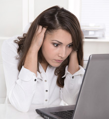 Frau deprimiert und verzweifelt im Büro mit dem Computer