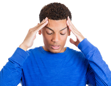Young stressed man having bad headache, hands on temples